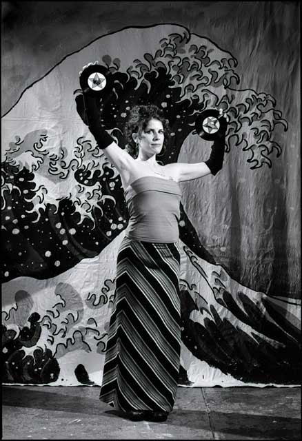Woman with two 45rpm records posed before Hokusai's Great Wave of Kanagawa